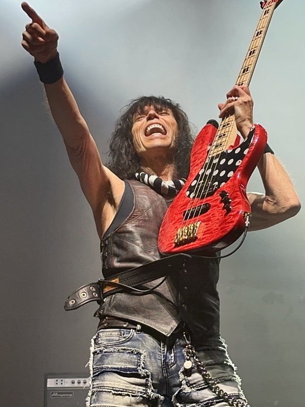 Concert photograph of a bassist performing with a red bass